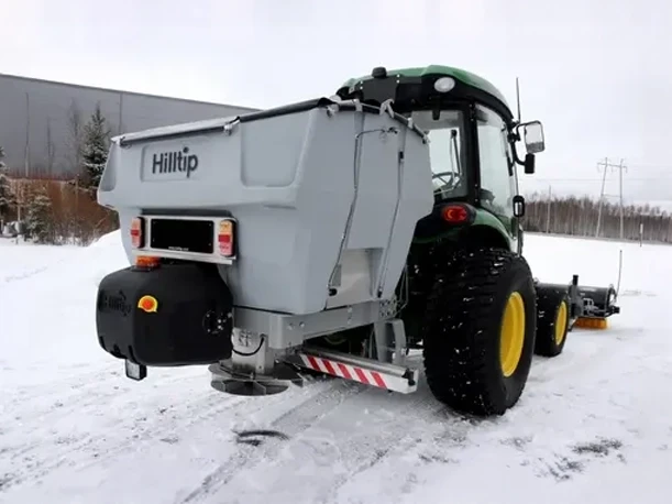 Hilltip Spreader and Sweeper — Mid-State Truck Equipment Fishers Greenfield IN Hilltip salt spreader and sweeper attachment mounted on a tractor, sold by Mid-State Truck Equipment in Fishers and Greenfield, Indiana