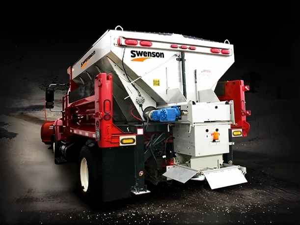 Swenson Salt Spreader In Action — Mid-State Truck Equipment Fishers Greenfield IN Swenson salt spreader actively spreading salt on a roadway, sold and serviced by Mid-State Truck Equipment in Fishers and Greenfield, Indiana