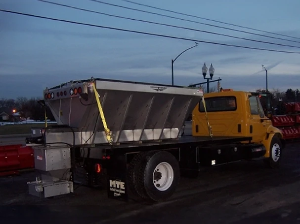 V-Box Salt Spreader — Mid-State Truck Equipment Fishers Greenfield IN Stainless steel V-box salt spreader installed on a truck at Mid-State Truck Equipment, serving Fishers and Greenfield, Indiana