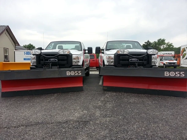 BOSS Plow Equipped Trucks — Mid-State Truck Equipment Fishers Greenfield IN Two red Ford trucks equipped with BOSS snow plows at Mid-State Truck Equipment in Fishers and Greenfield, Indiana